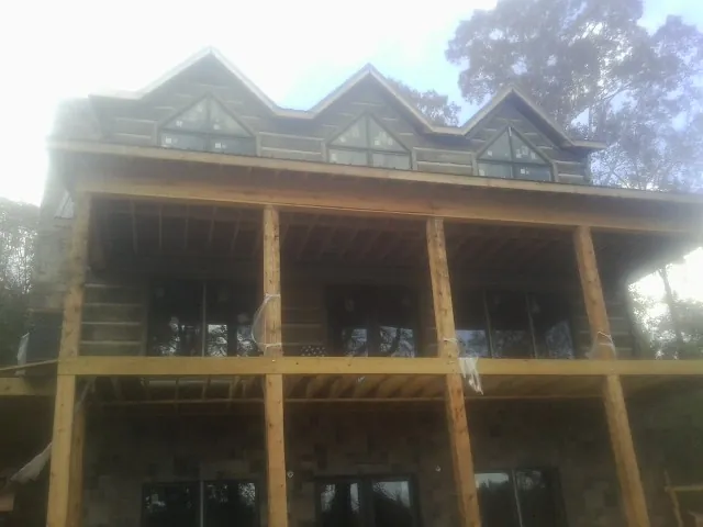 Dormers and porch framing on a large log home under construction — Roof Coating work by our crew in Columbiana