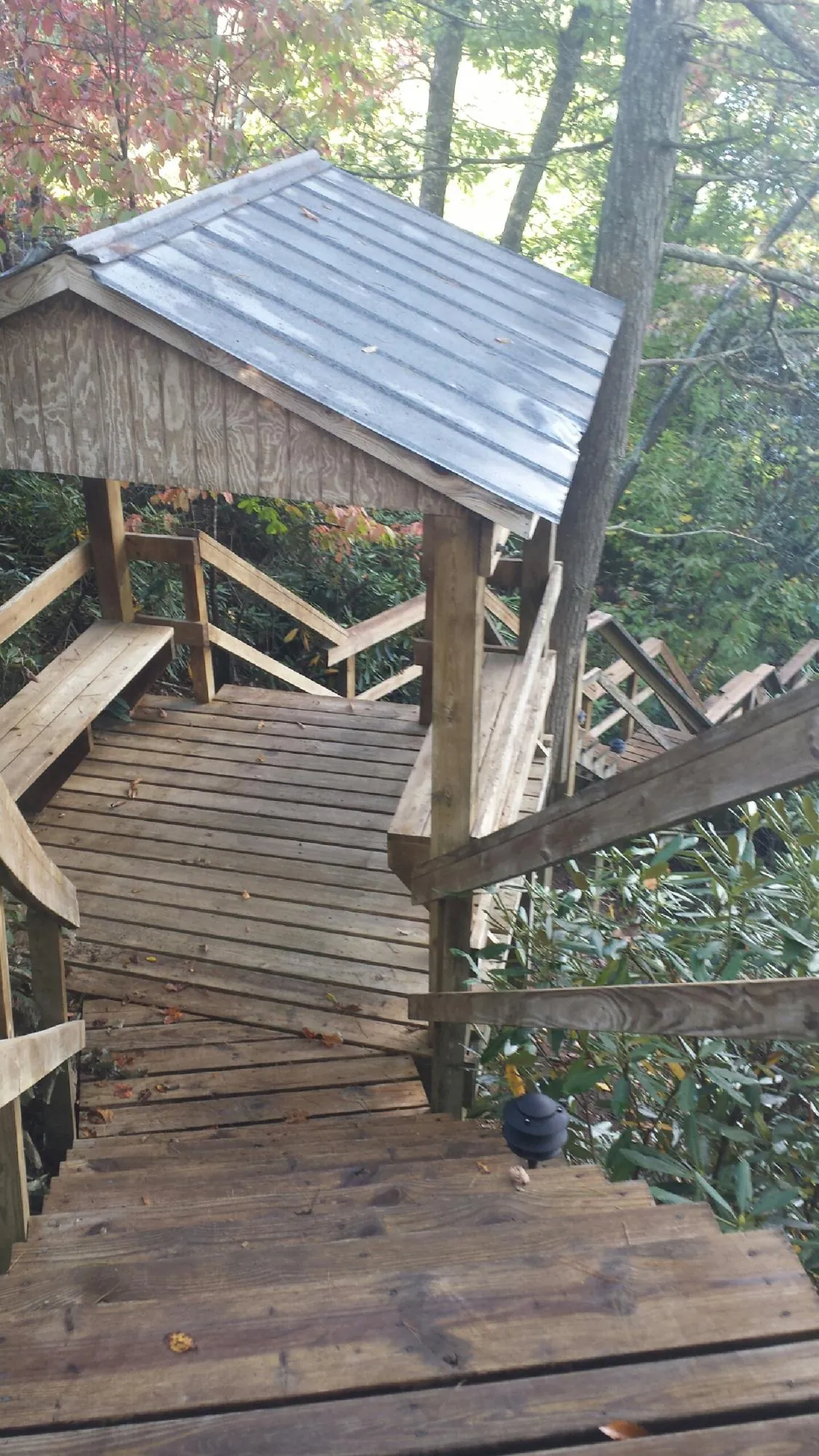 Metal roofed shelter over wooden steps on a wooded walkway — Skylight Repair & Installation work by our crew in Columbiana