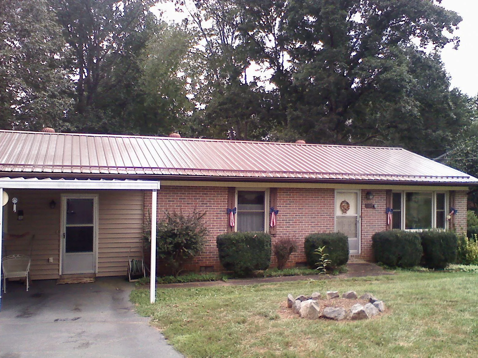 Bronze metal roof and carport on a brick ranch home — Roof Repair work by our crew in Columbiana